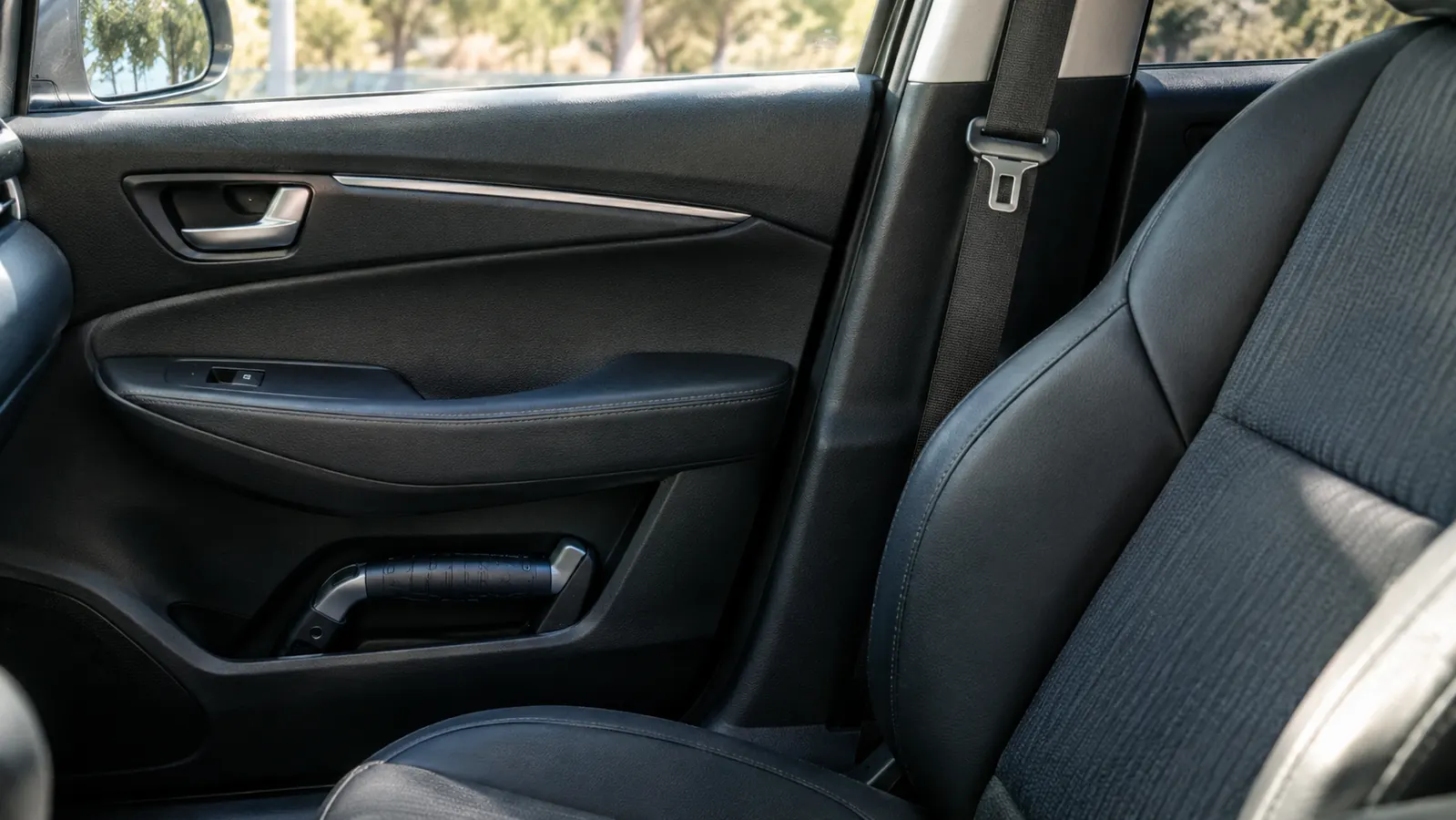 A portable car assist handle tucked in the door pocket of a car, ready for the next trip.